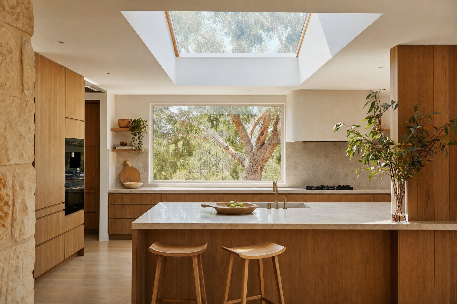 A premium contemporary Canberra kitchen with timber cabinetry, stone benchtops and a skylight overlooking native gum trees