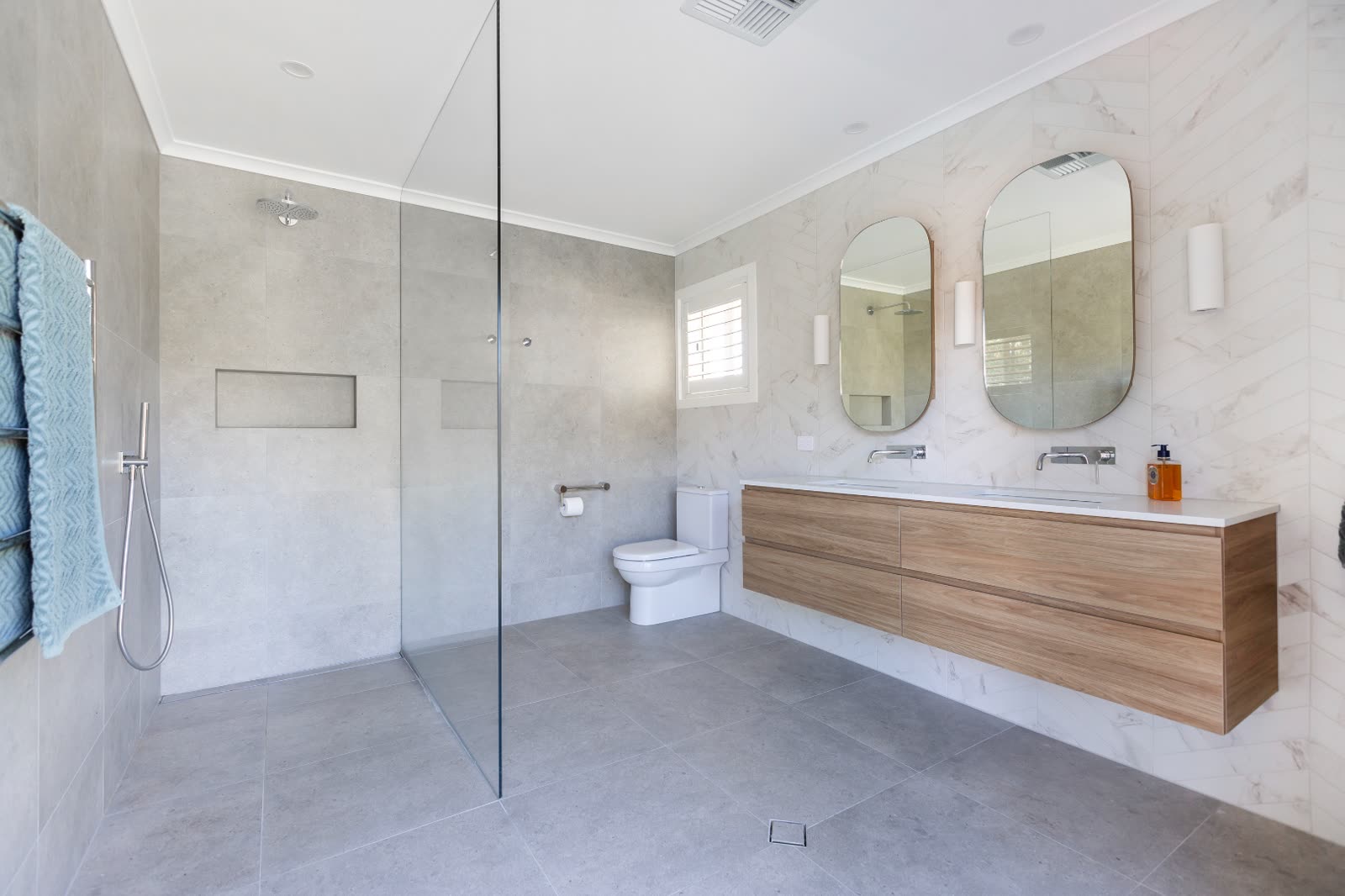 Renovated main bathroom in Weetangera with marble tile and dual mirrors